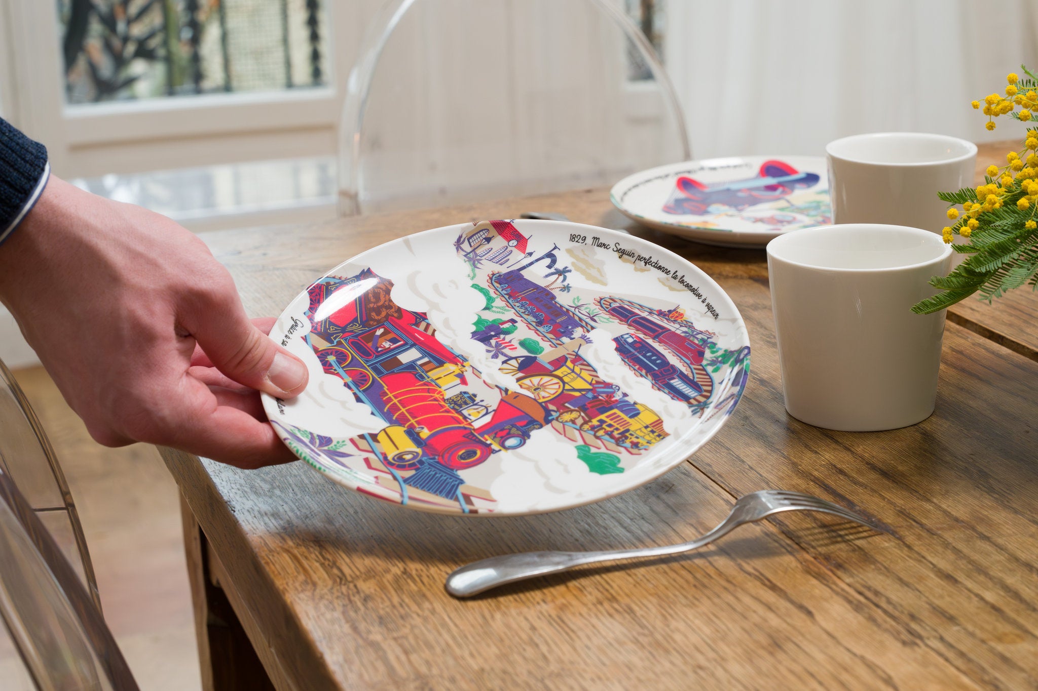 Assiette en mélamine illustrée représentant la locomotive à vapeur et le progrès industriel.